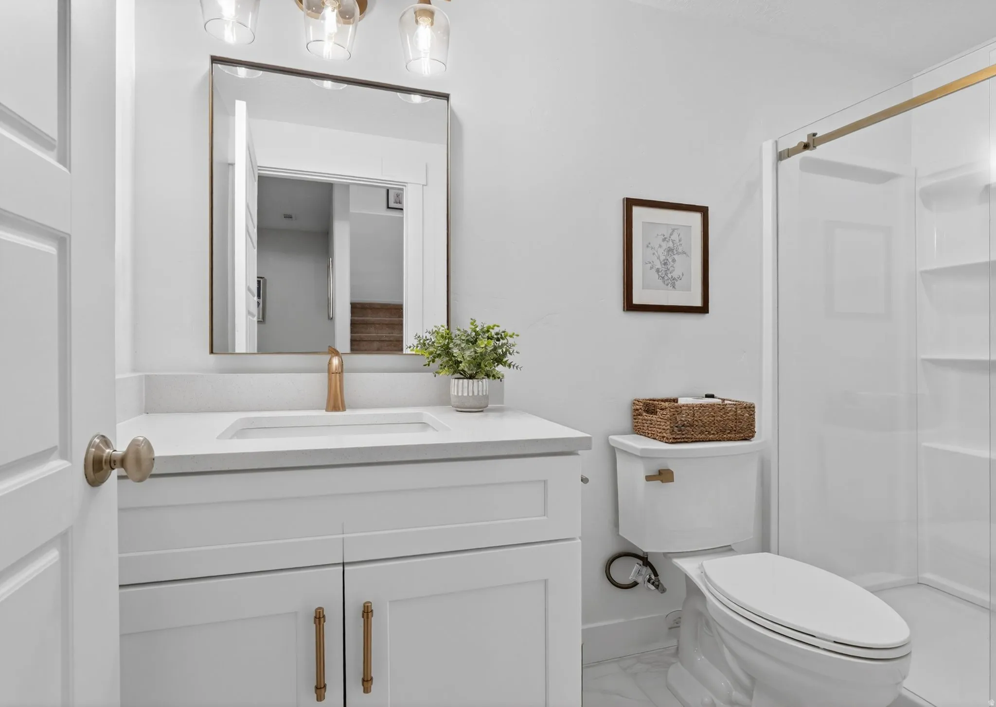 Bathroom with vanity, a shower stall, and light marble finish floors