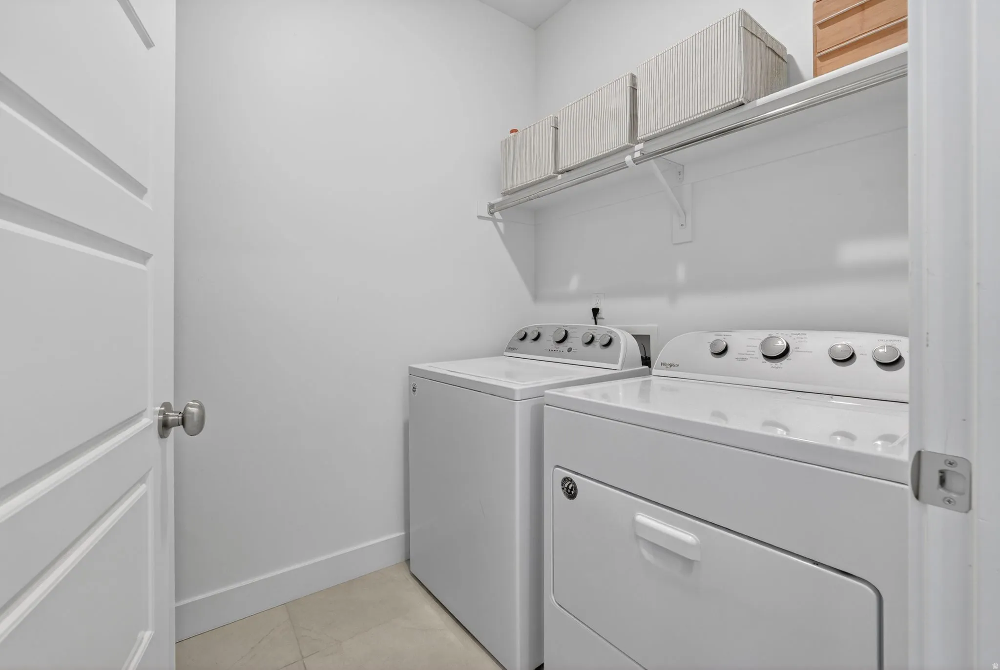 Laundry area featuring washer and dryer and light tile patterned flooring