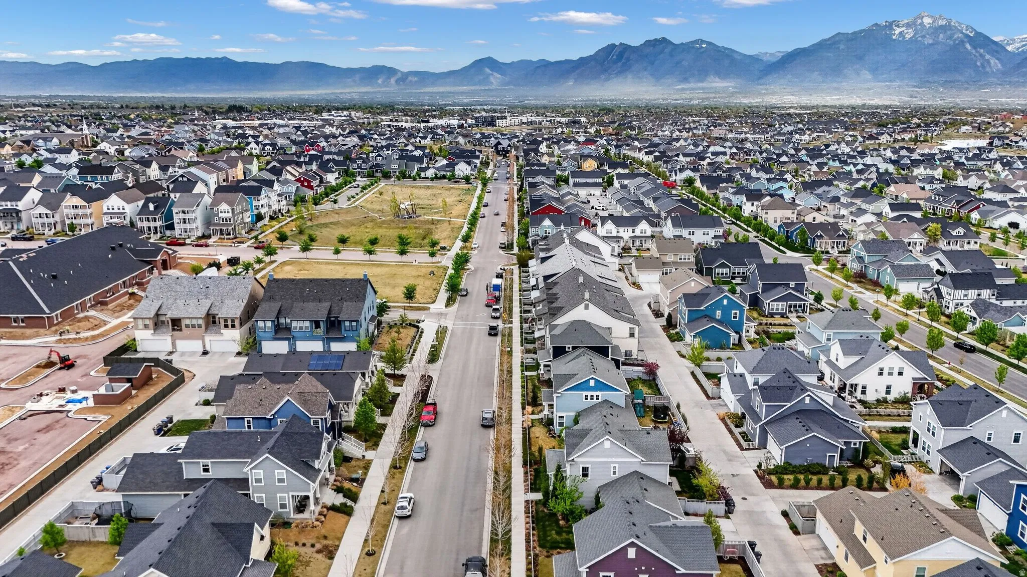 Aerial view of property and surrounding area featuring nearby suburban area and mountains