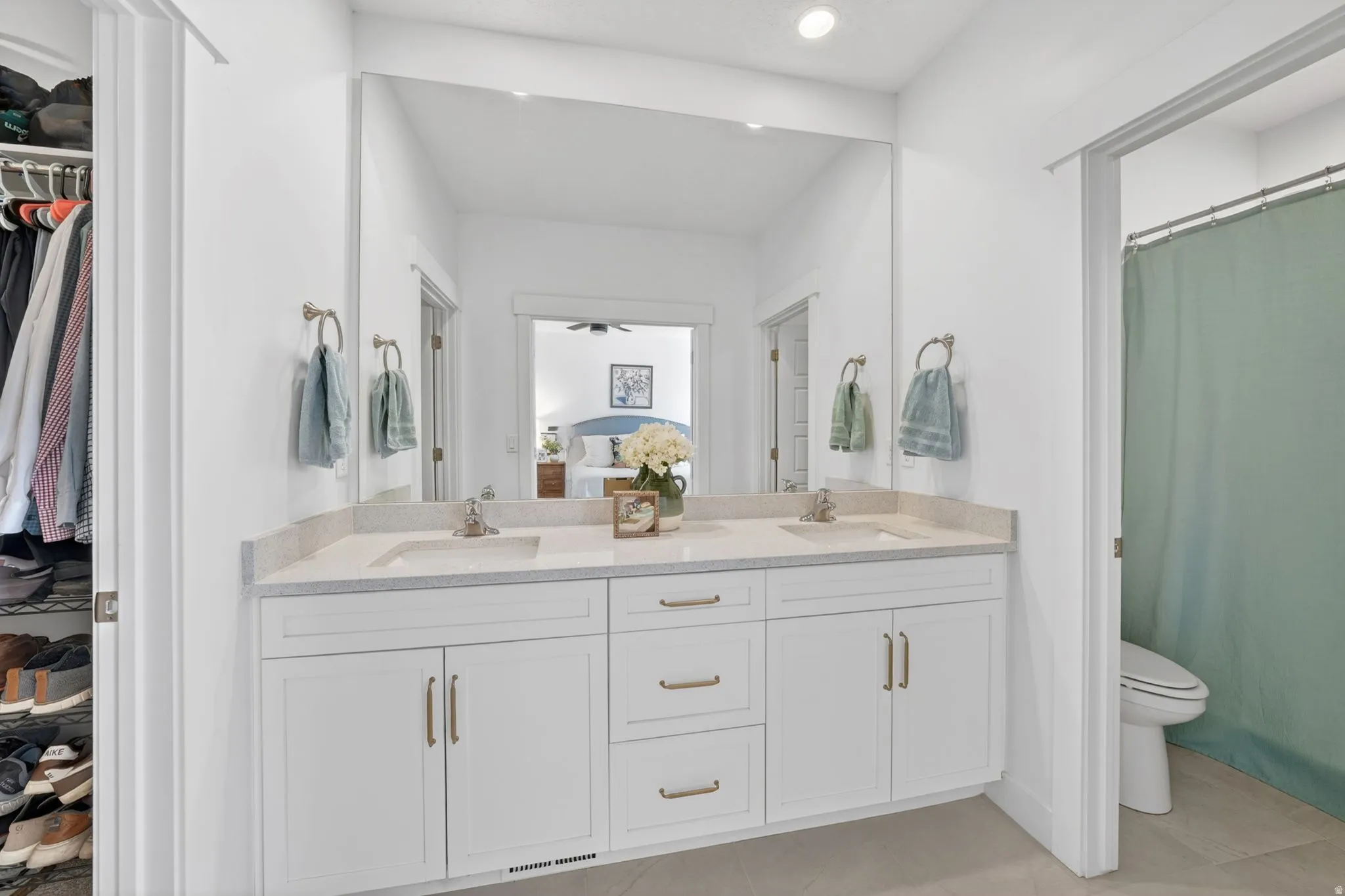 Ensuite bathroom featuring a walk in closet, double vanity, a shower with curtain, recessed lighting, and light tile patterned floors