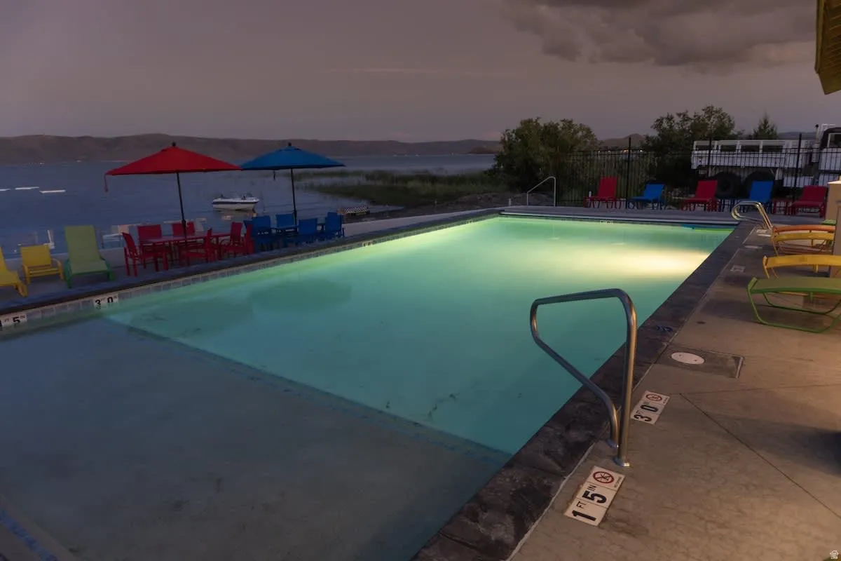 Pool at dusk featuring a community pool and a patio area