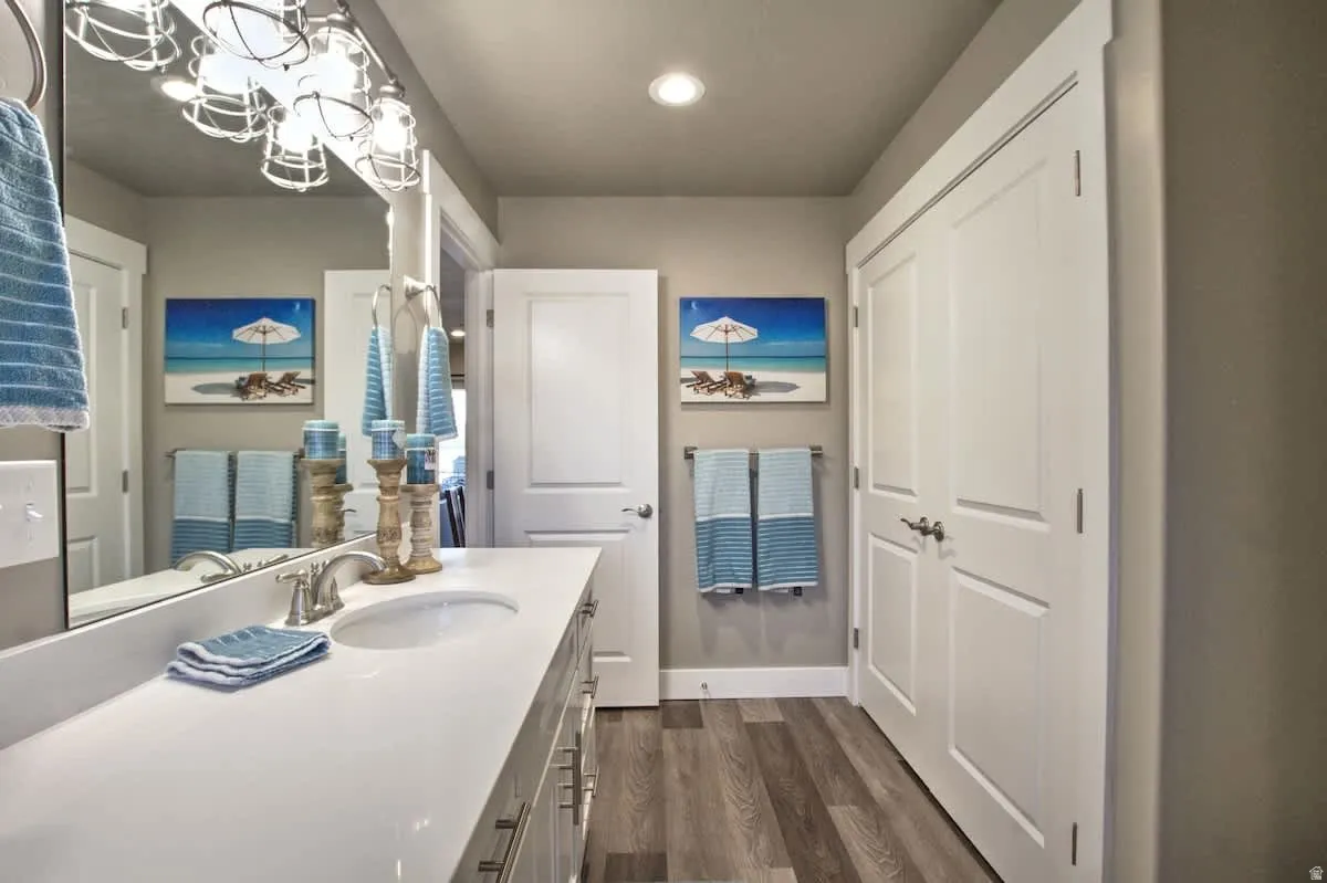Bathroom with vanity, dark wood-style flooring, and a chandelier