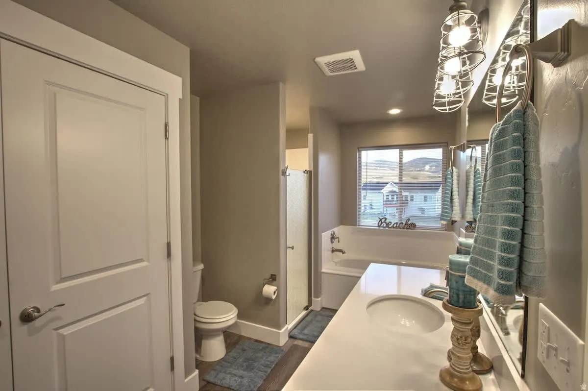 Full bathroom featuring vanity, a stall shower, a garden tub, and recessed lighting