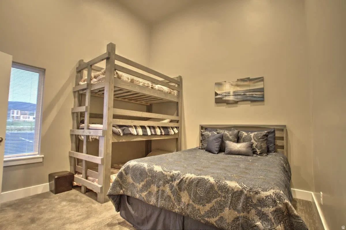 Bedroom featuring light carpet and baseboards