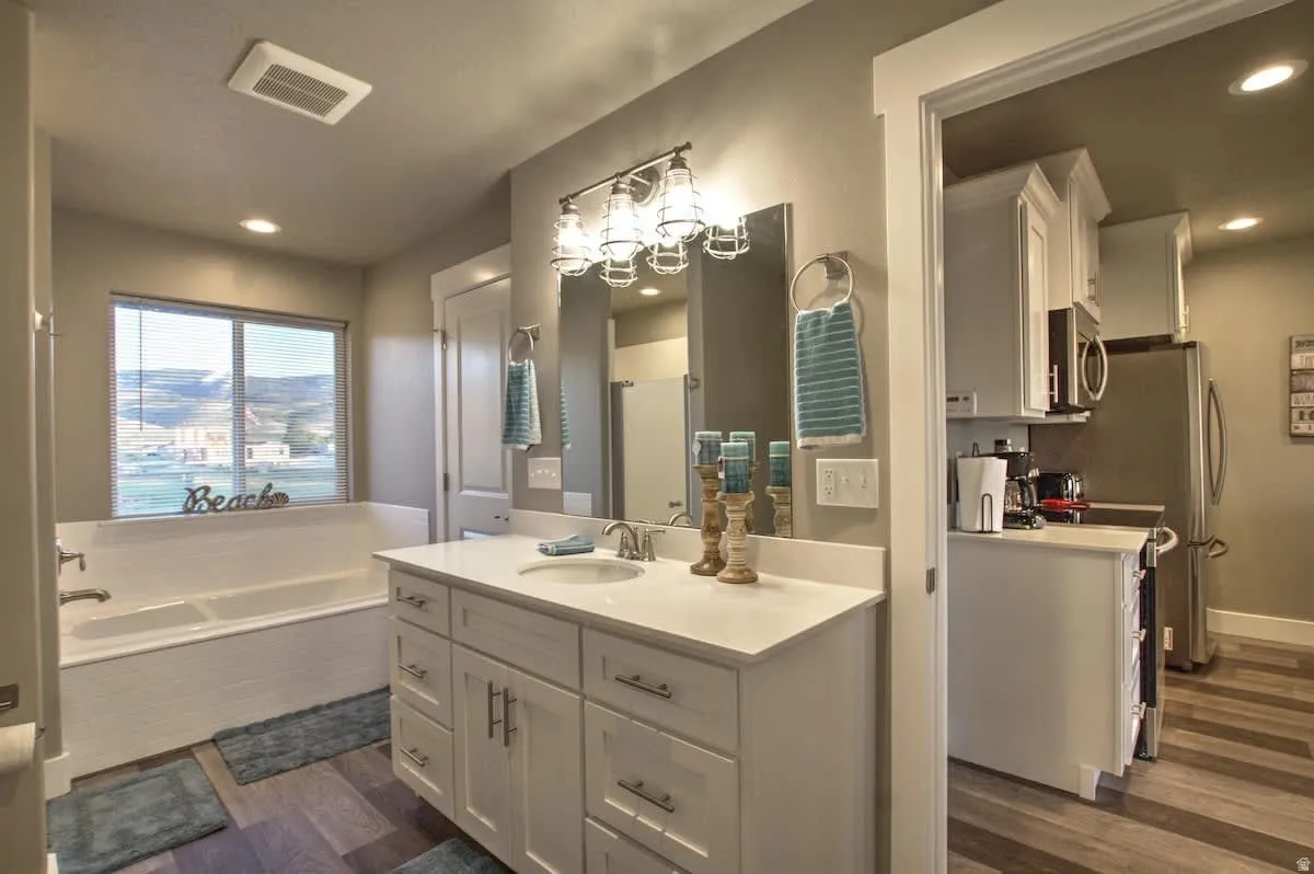 Bathroom with recessed lighting, vanity, dark wood-style floors, a bath, and a shower stall