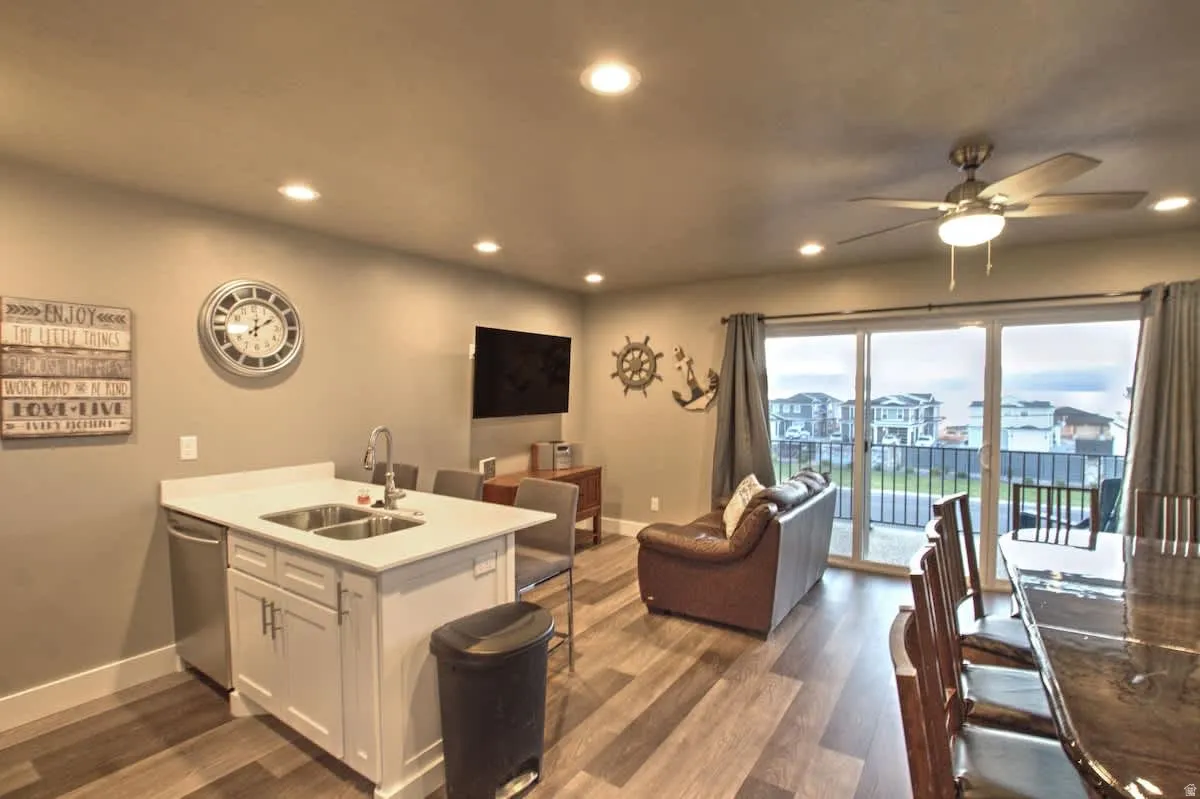 Kitchen featuring a peninsula, open floor plan, dark wood-type flooring, white cabinets, and recessed lighting