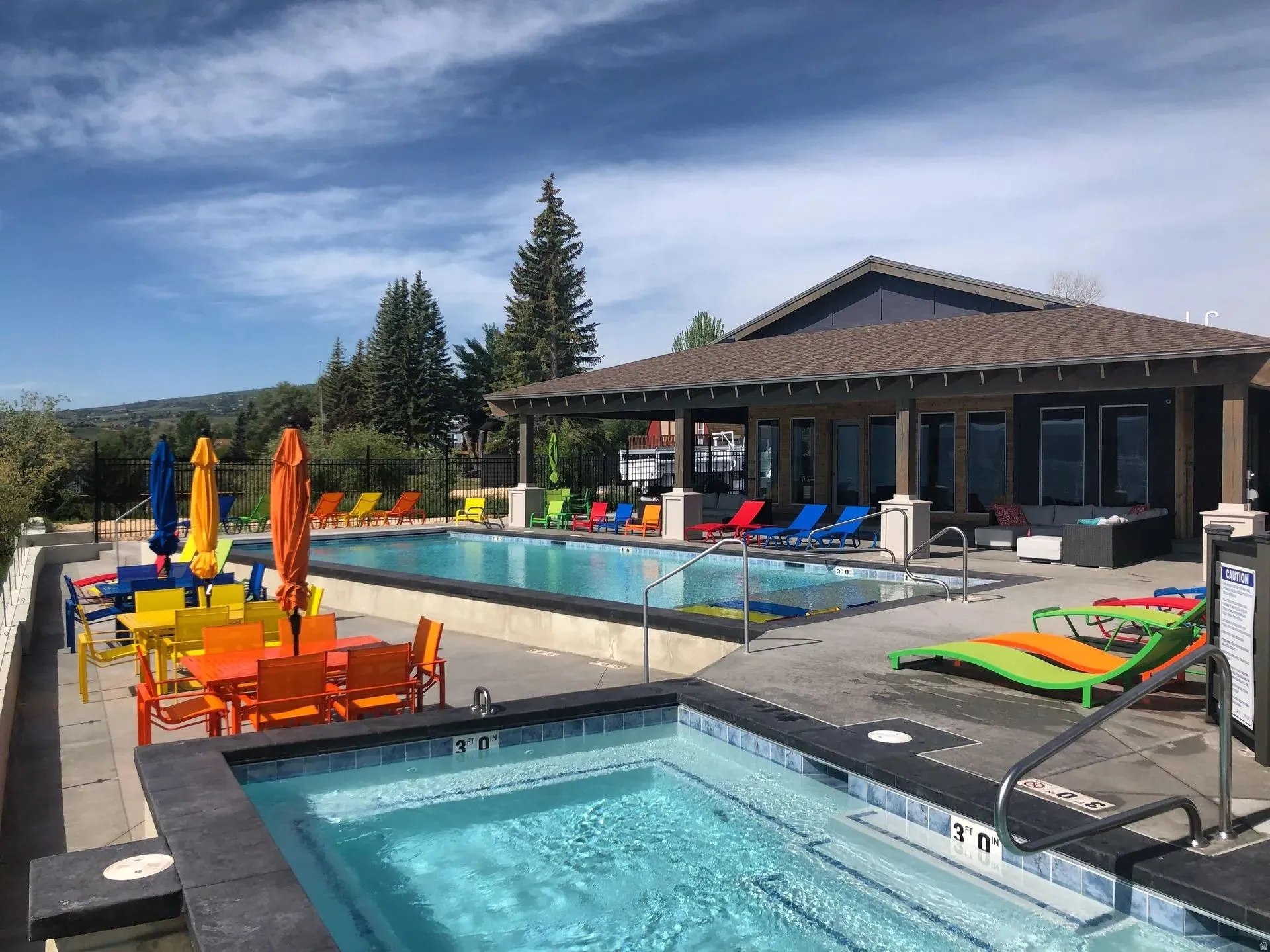 Community pool with a patio area, a community hot tub, and outdoor lounge area