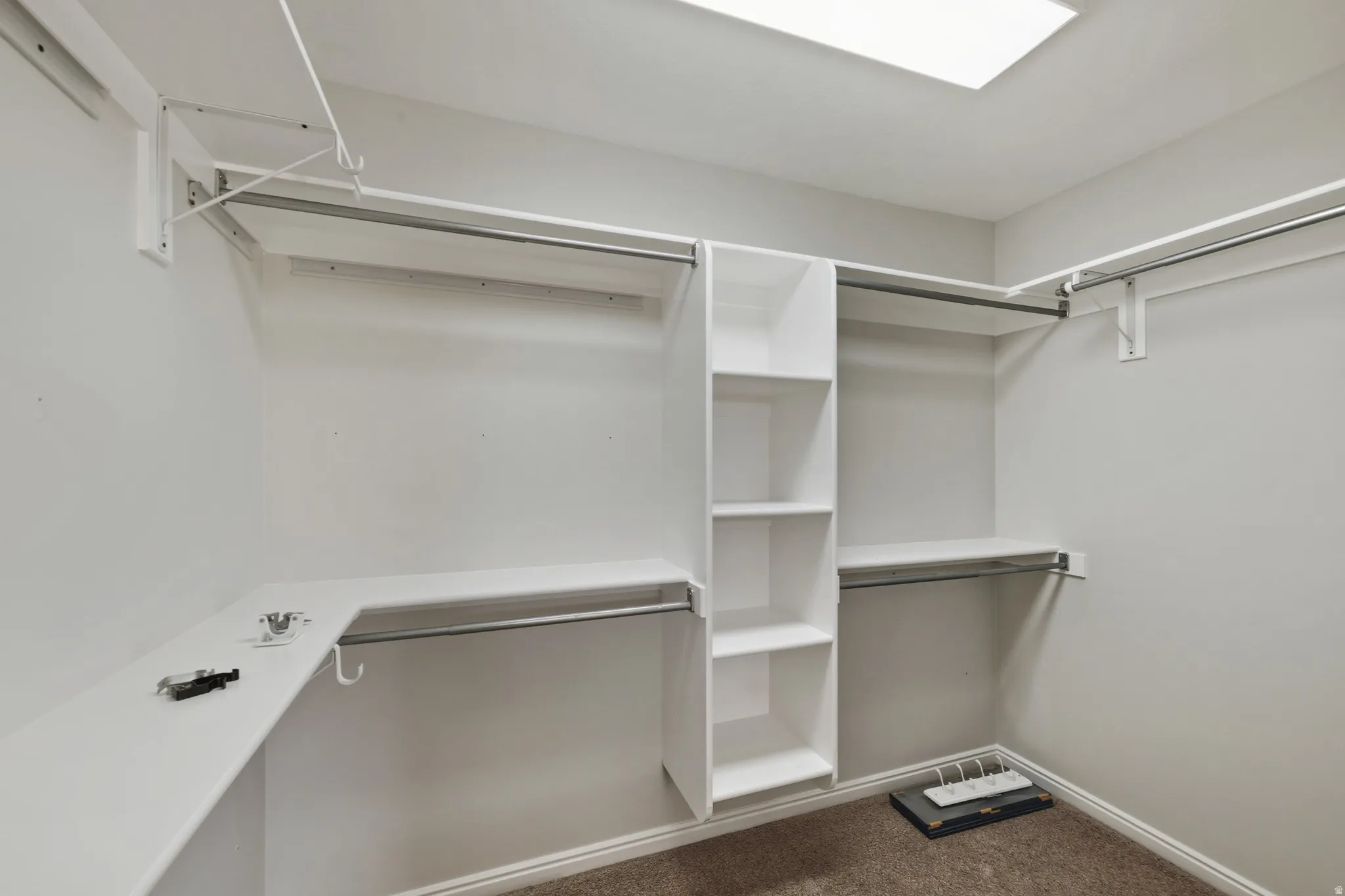 Walk in closet with dark colored carpet