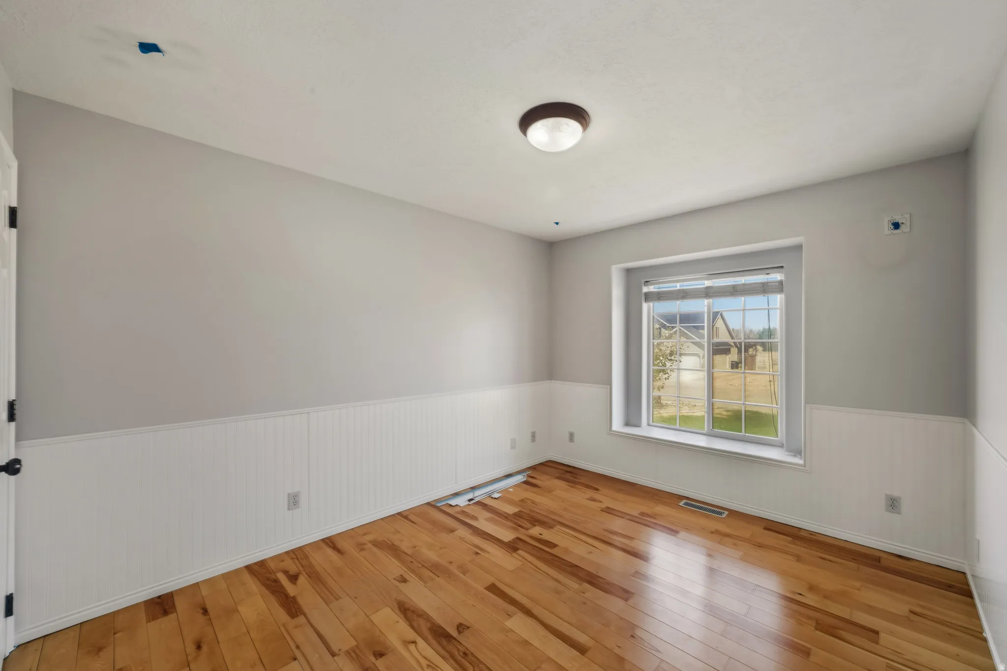 Unfurnished room featuring wainscoting and light wood finished floors