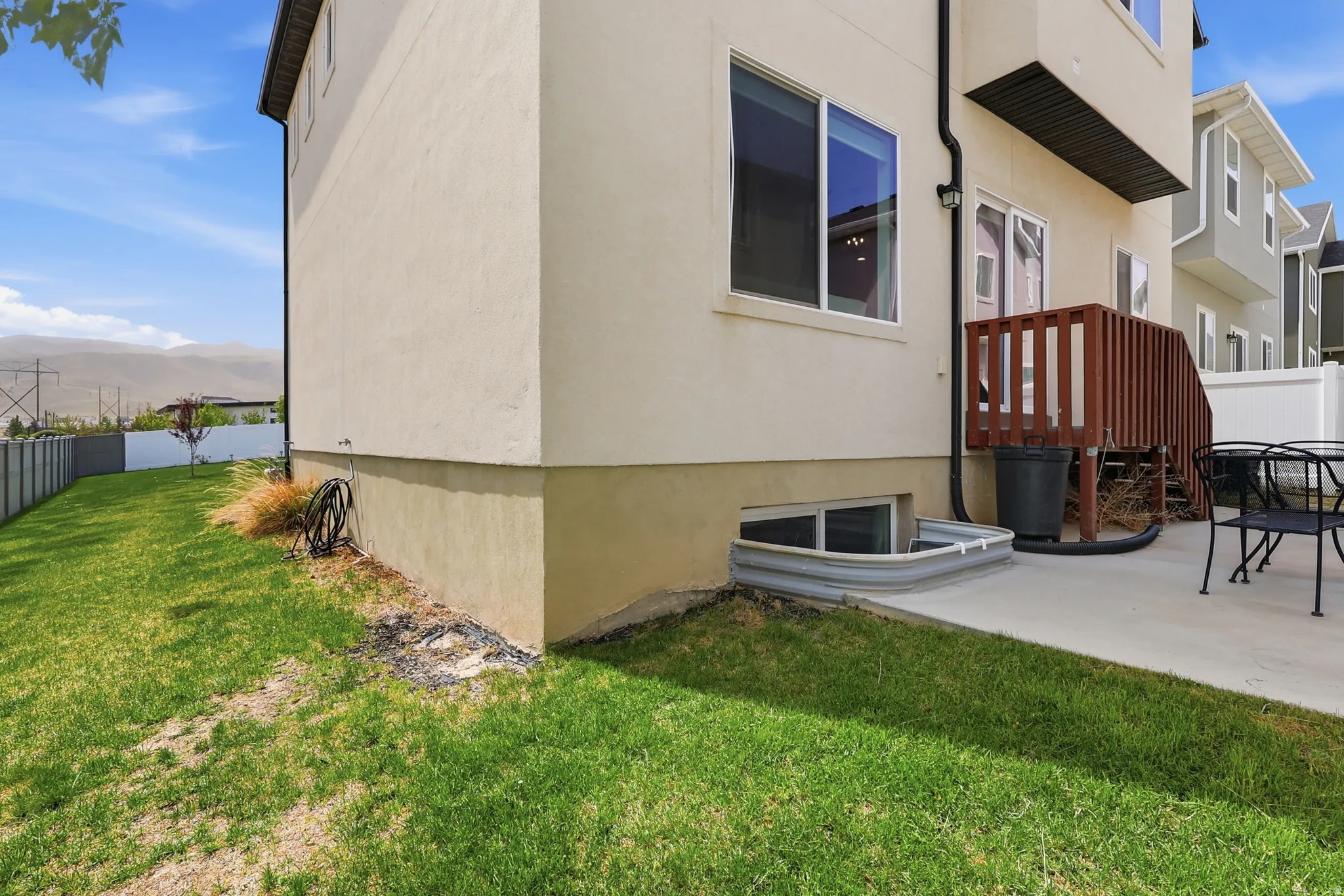 View of side of property with a mountain view, stucco siding, and a patio