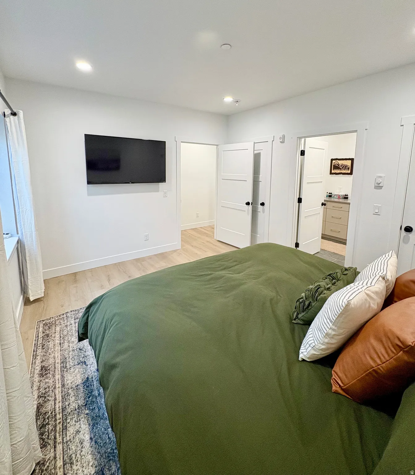 Bedroom featuring light wood-style flooring, ensuite bathroom, and recessed lighting