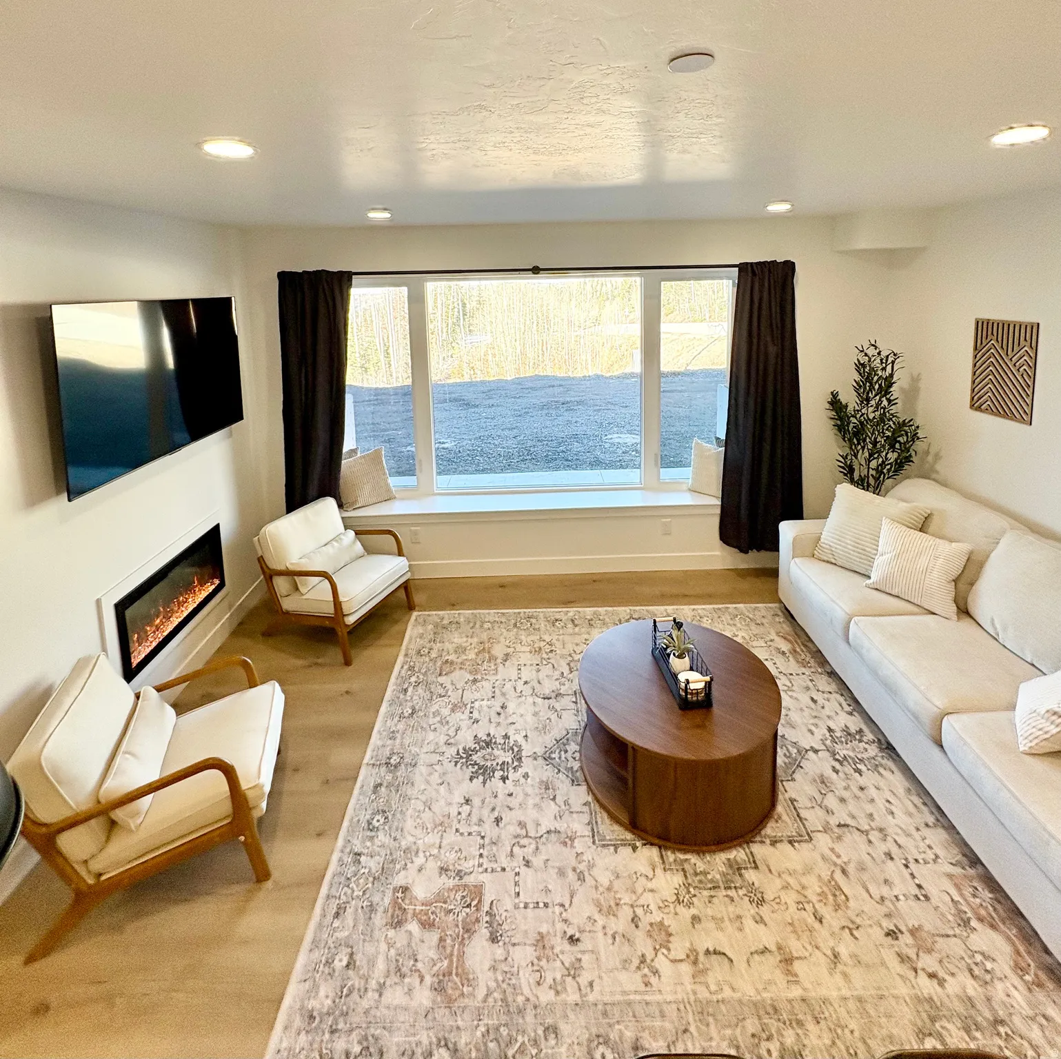 Living room featuring recessed lighting, a glass covered fireplace, and light wood-type flooring