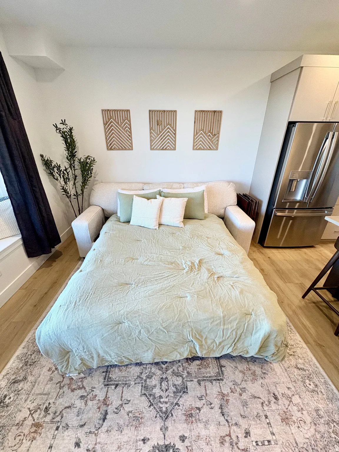 Bedroom featuring stainless steel refrigerator with ice dispenser and light wood-type flooring