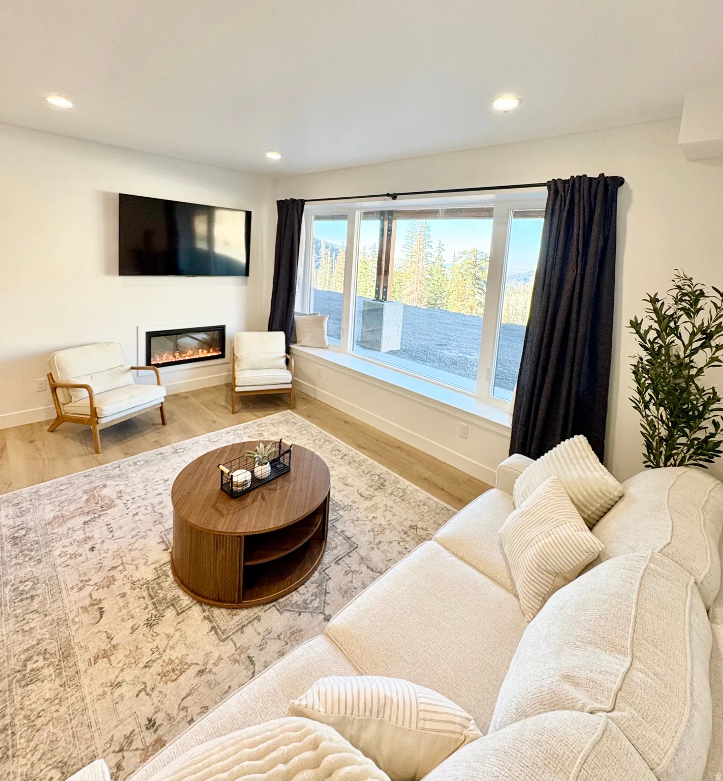 Living area with wood finished floors, a glass covered fireplace, and recessed lighting