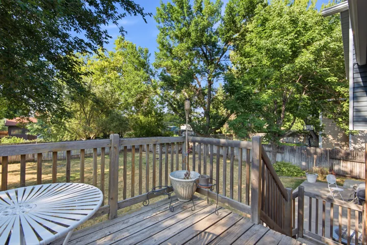 Wood-finish deck with railing, stairs, and a concrete patio
