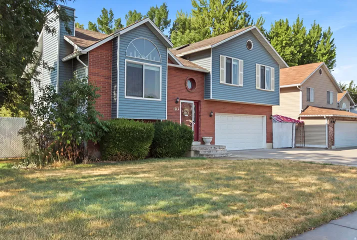 Brick and siding exterior with a prominent arched window and a circular accent window