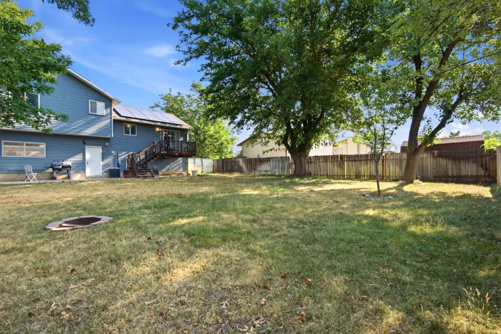 Expansive backyard with a wood privacy fence and mature trees