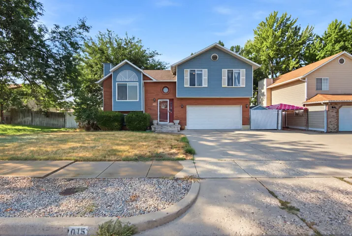 Two-story exterior featuring brick and blue siding, an attached two-car garage, and a concrete driveway