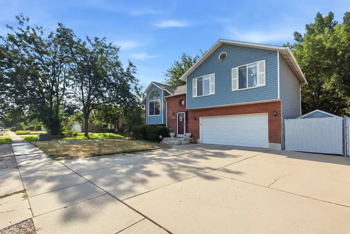 Two-story residence featuring brick and siding facade, an attached two-car garage, and a chain-link fence