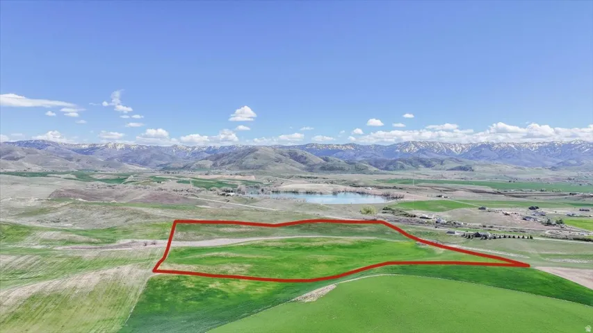 Aerial view of property and surrounding area featuring property boundaries highlighted and a water and mountain view