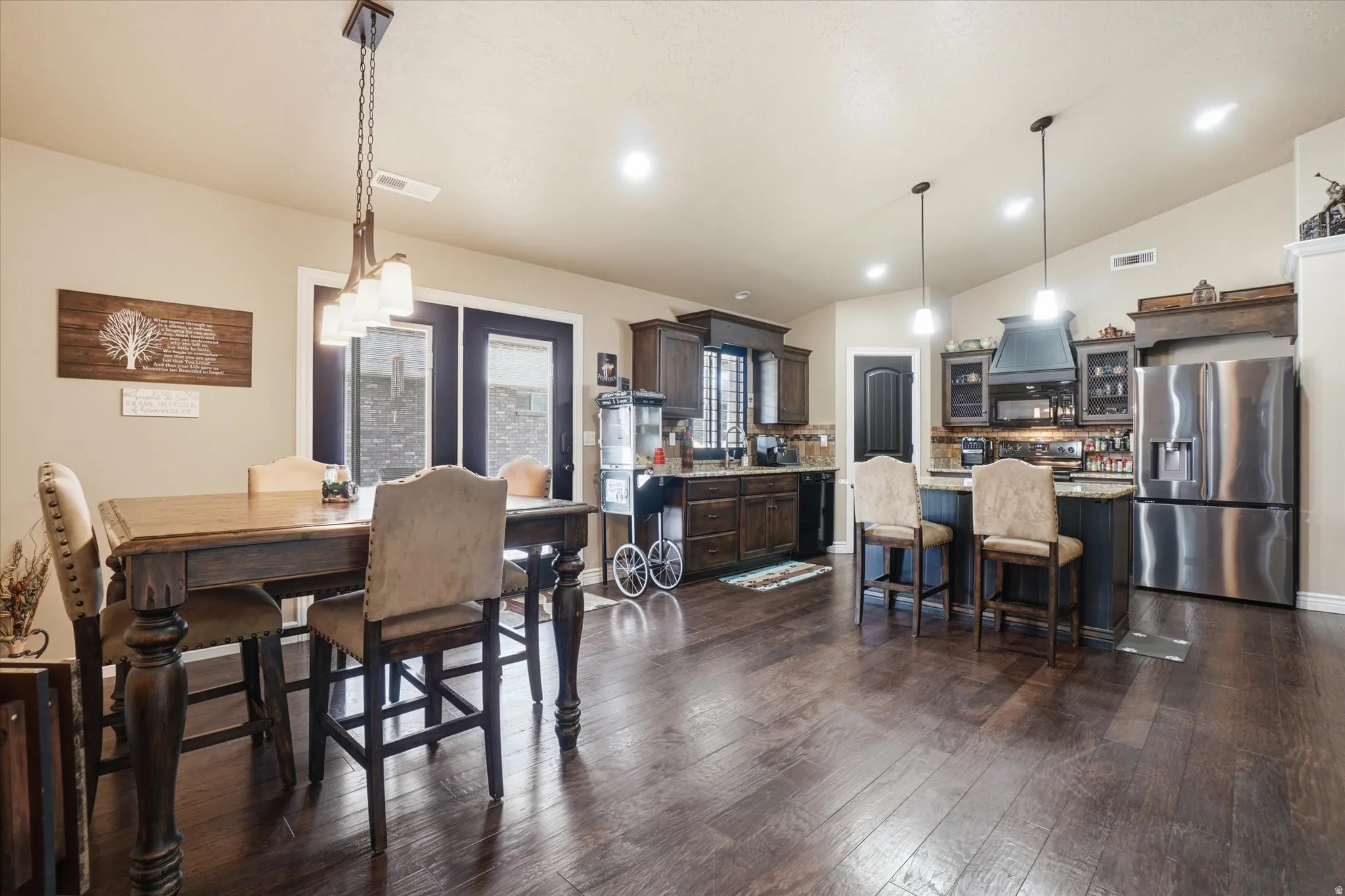 Dining room featuring lofted ceiling, dark wood finished floors, and recessed lighting