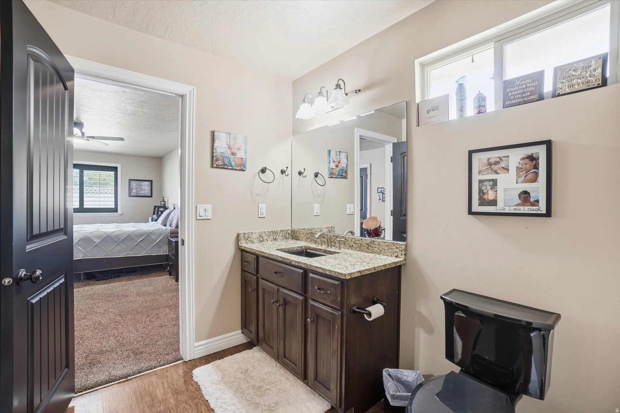 Bathroom with vanity, light wood finished floors, a textured ceiling, ensuite bath, and ceiling fan