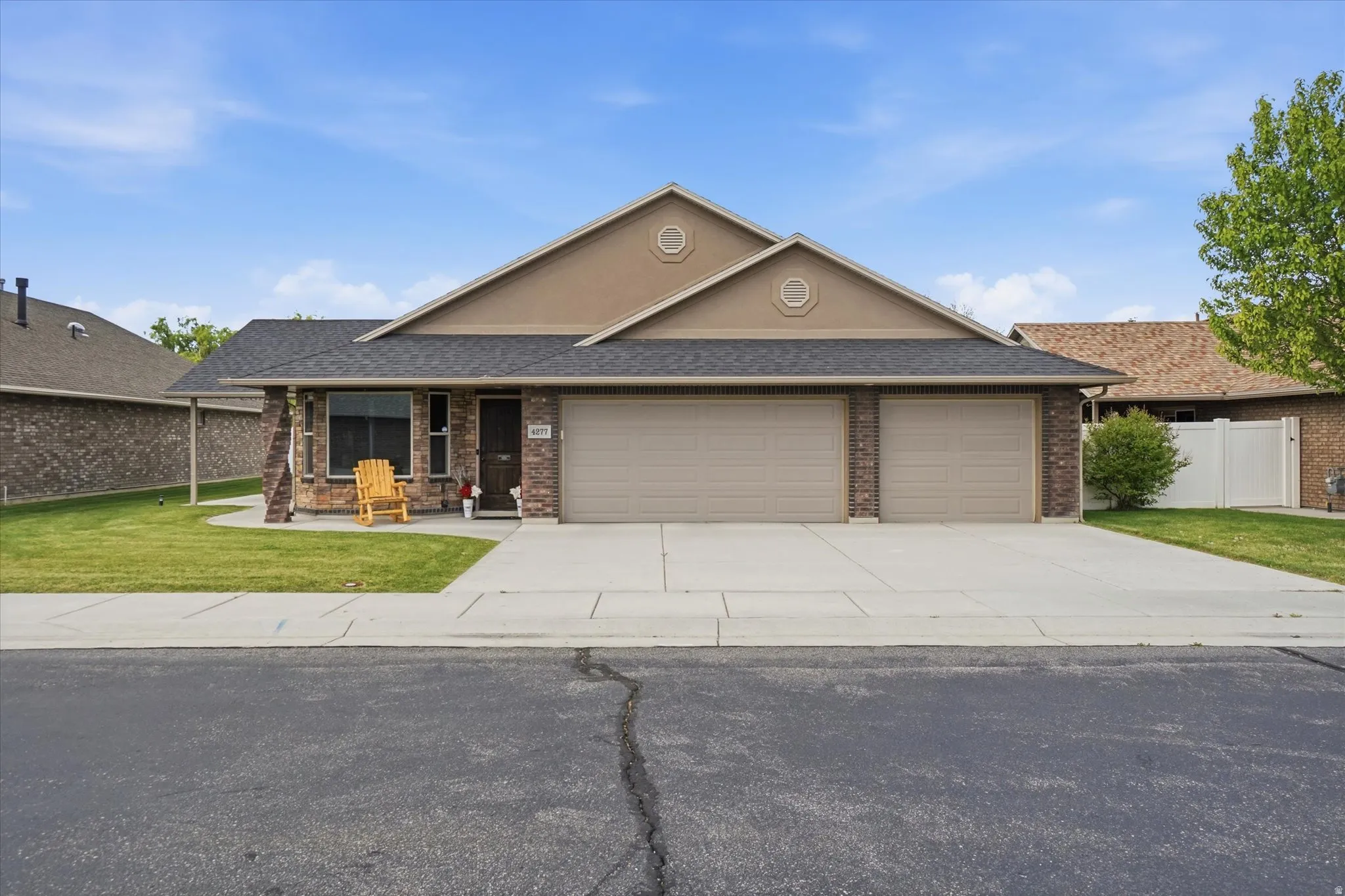 View of front of home featuring a garage, driveway, brick siding, and a shingled roof