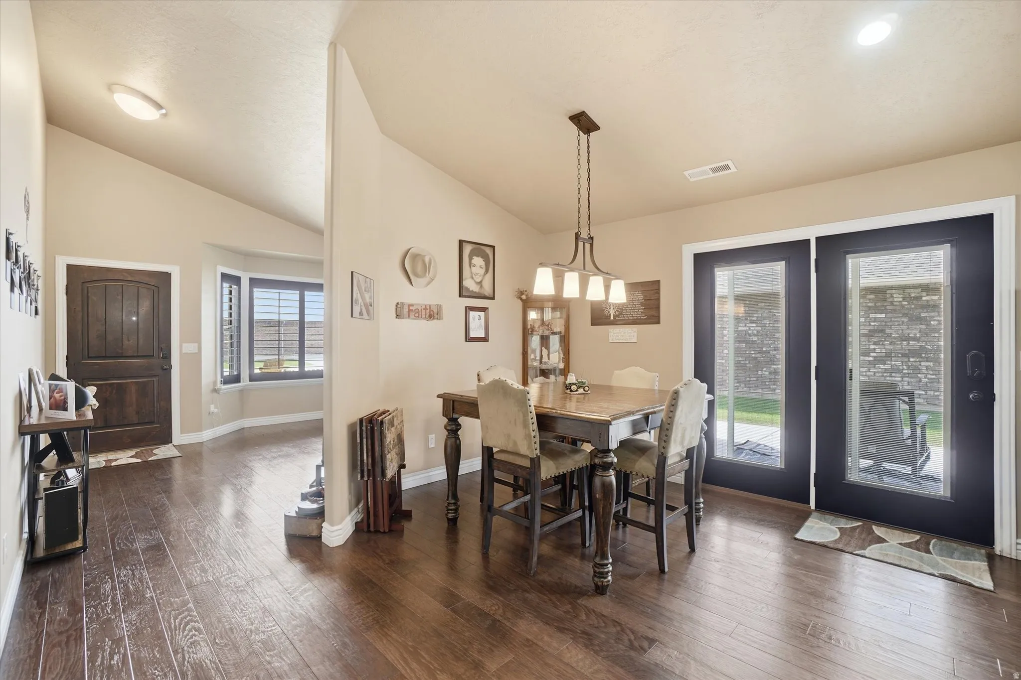 Dining space with dark wood finished floors and lofted ceiling
