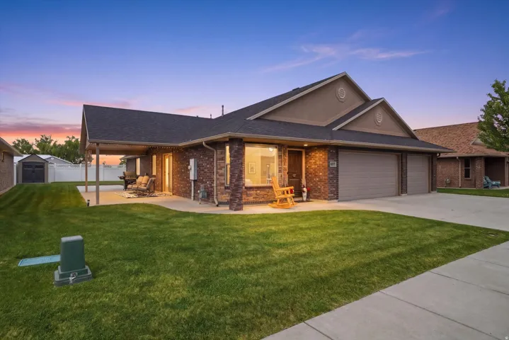 Ranch-style home featuring brick siding, a garage, concrete driveway, and a shingled roof