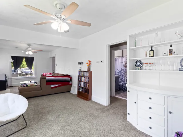Light-toned carpeted flooring with a white built-in hutch featuring open shelving and cabinet storage