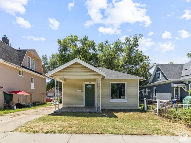 Single-story property featuring light-colored horizontal siding, a covered front porch, and a dark green entry door