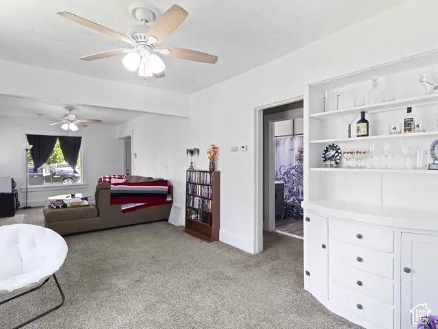 Light-toned carpeted flooring with a white built-in hutch featuring open shelving and cabinet storage