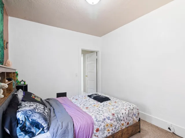 Carpeted room featuring a ceiling-mounted light fixture, white walls, and white trim