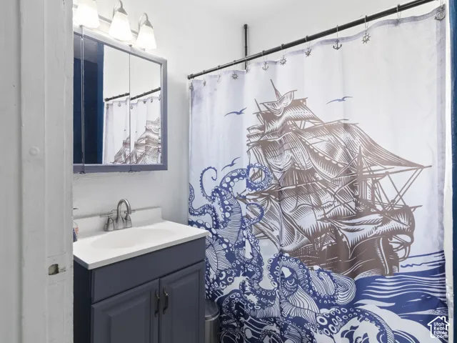 Bathroom featuring a vanity with a white countertop and a single basin sink