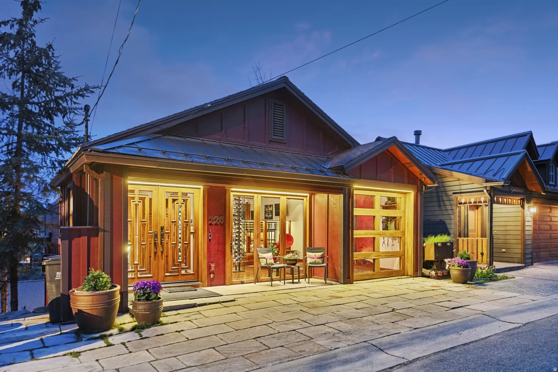 View of front of property featuring board and batten siding, a standing seam roof, a porch, an attached garage, and driveway