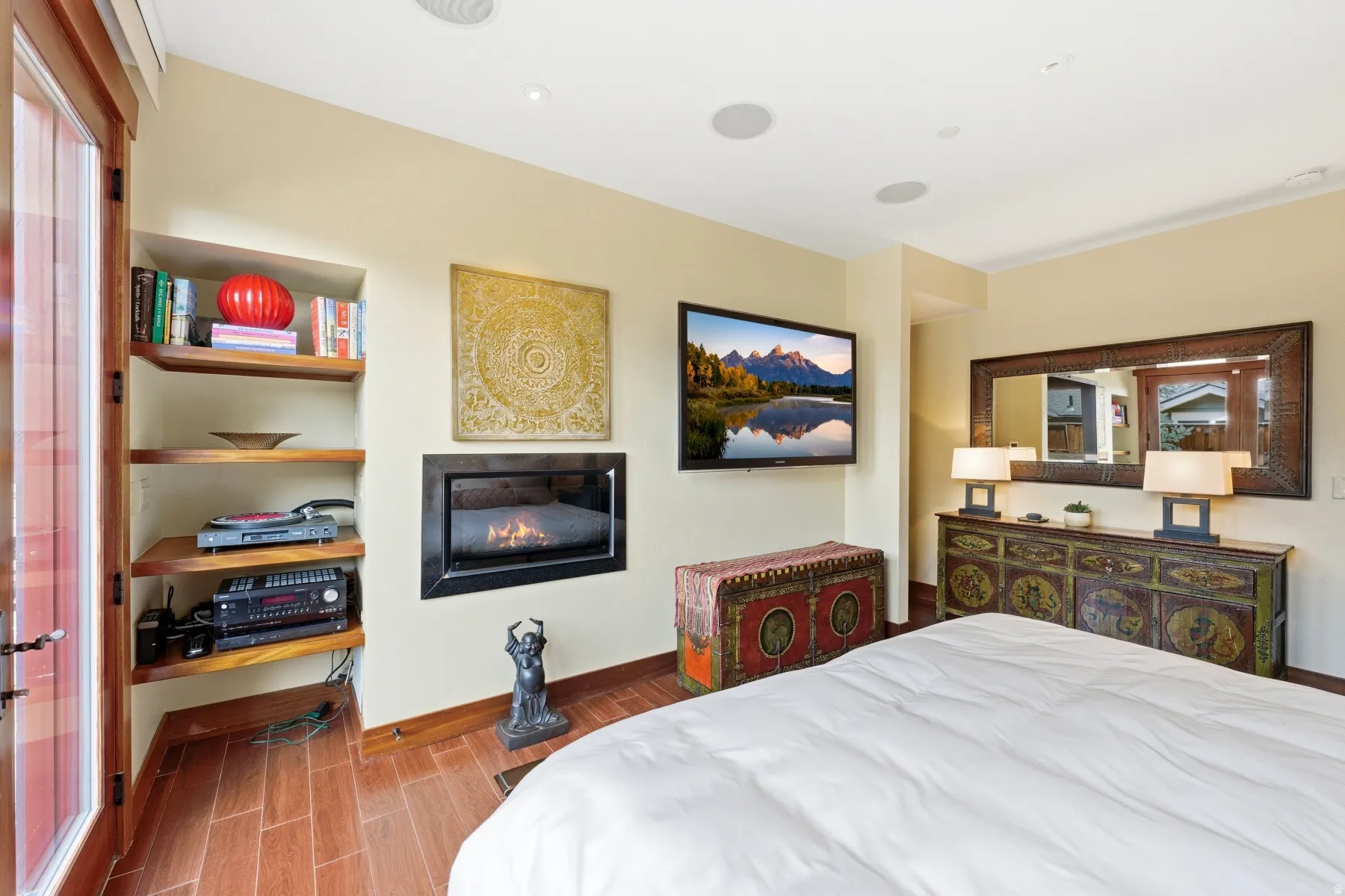 Bedroom featuring wood tiled floors and a glass covered fireplace