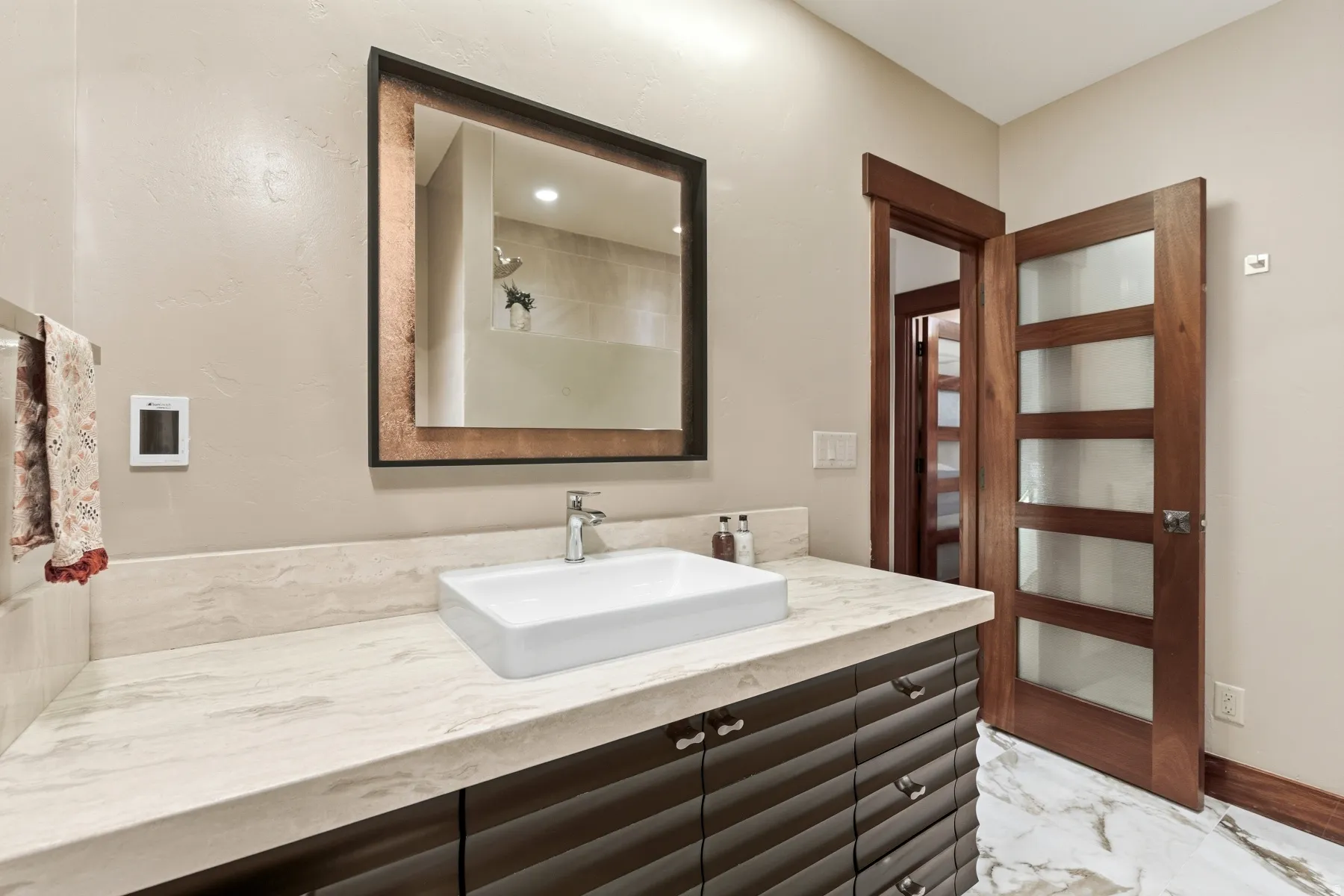 Bathroom featuring vanity, a shower, and light marble finish floors