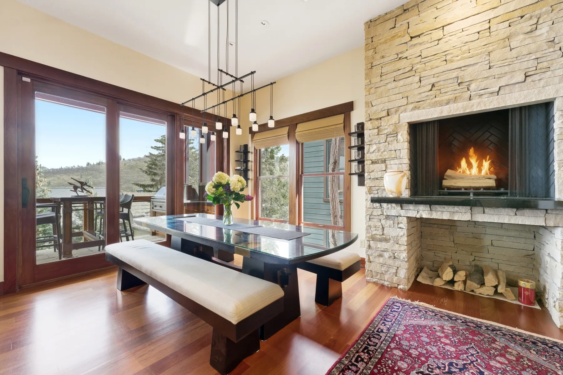 Dining space with a warm lit fireplace and wood finished floors