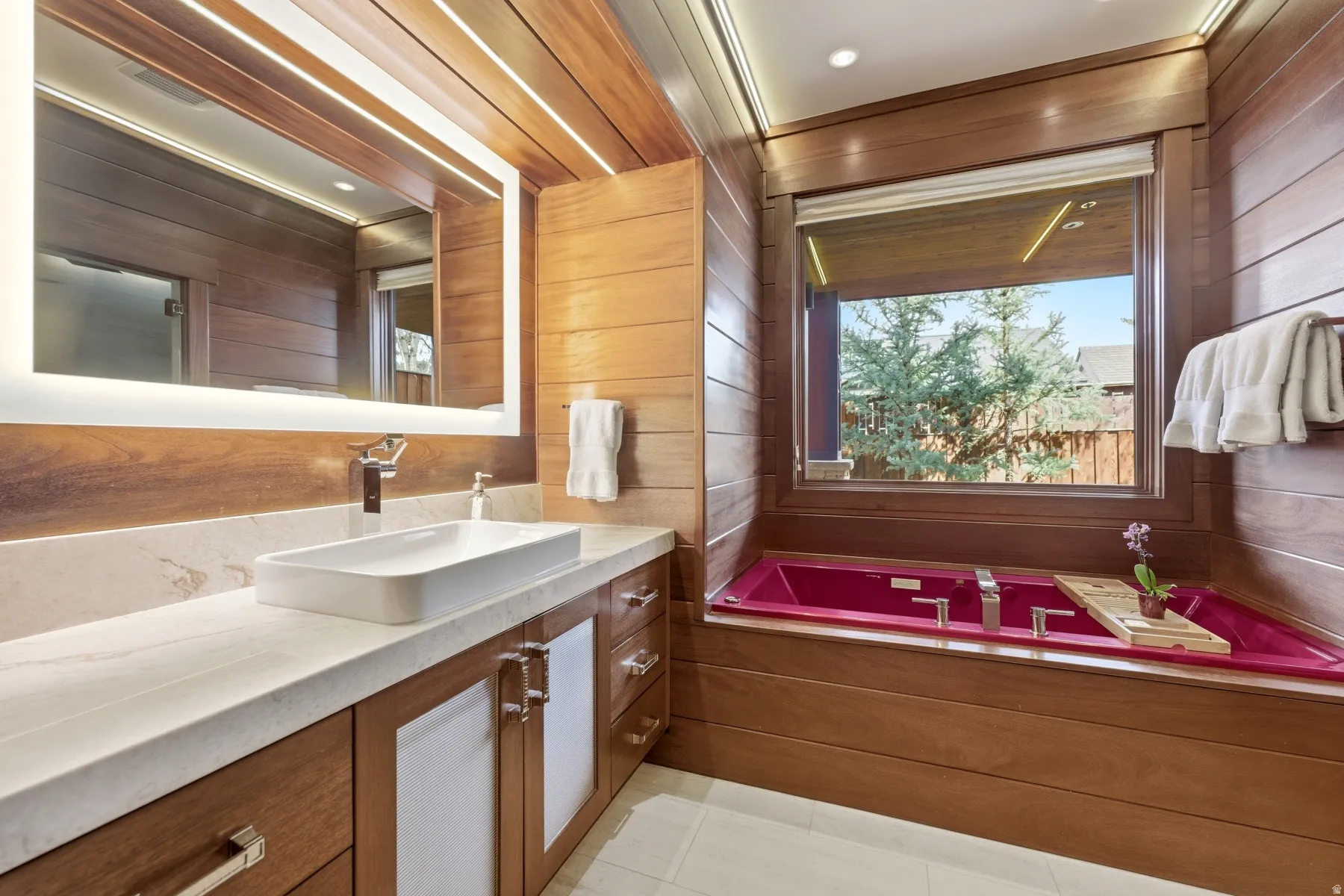 Full bath with vanity, wooden walls, and a bath
