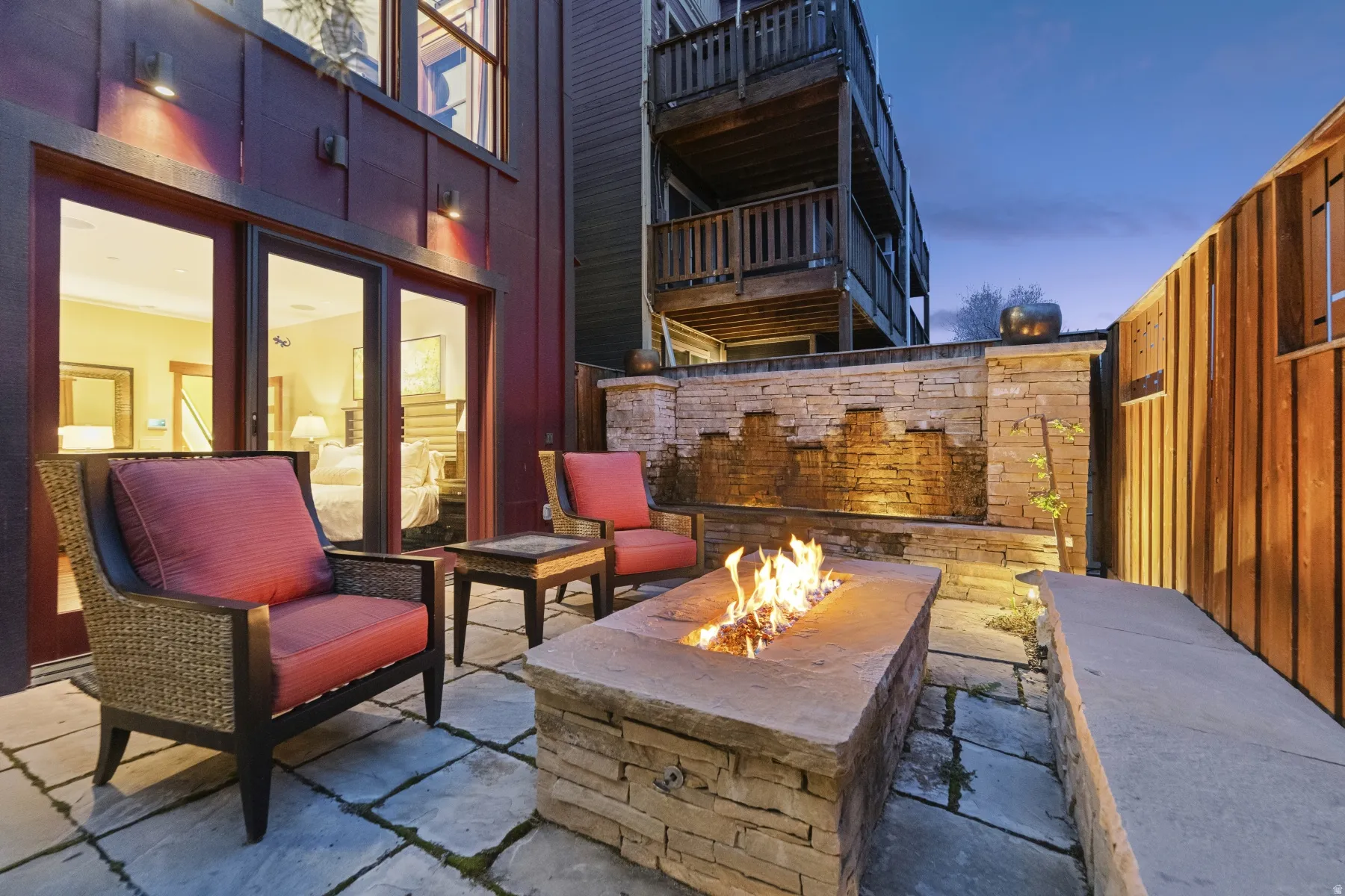 Patio terrace at dusk with a fenced backyard, a patio, and an outdoor fire pit