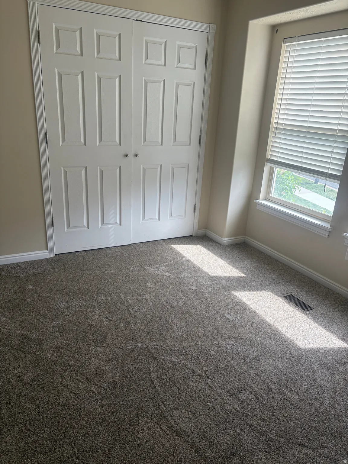 Unfurnished bedroom featuring dark colored carpet and a closet