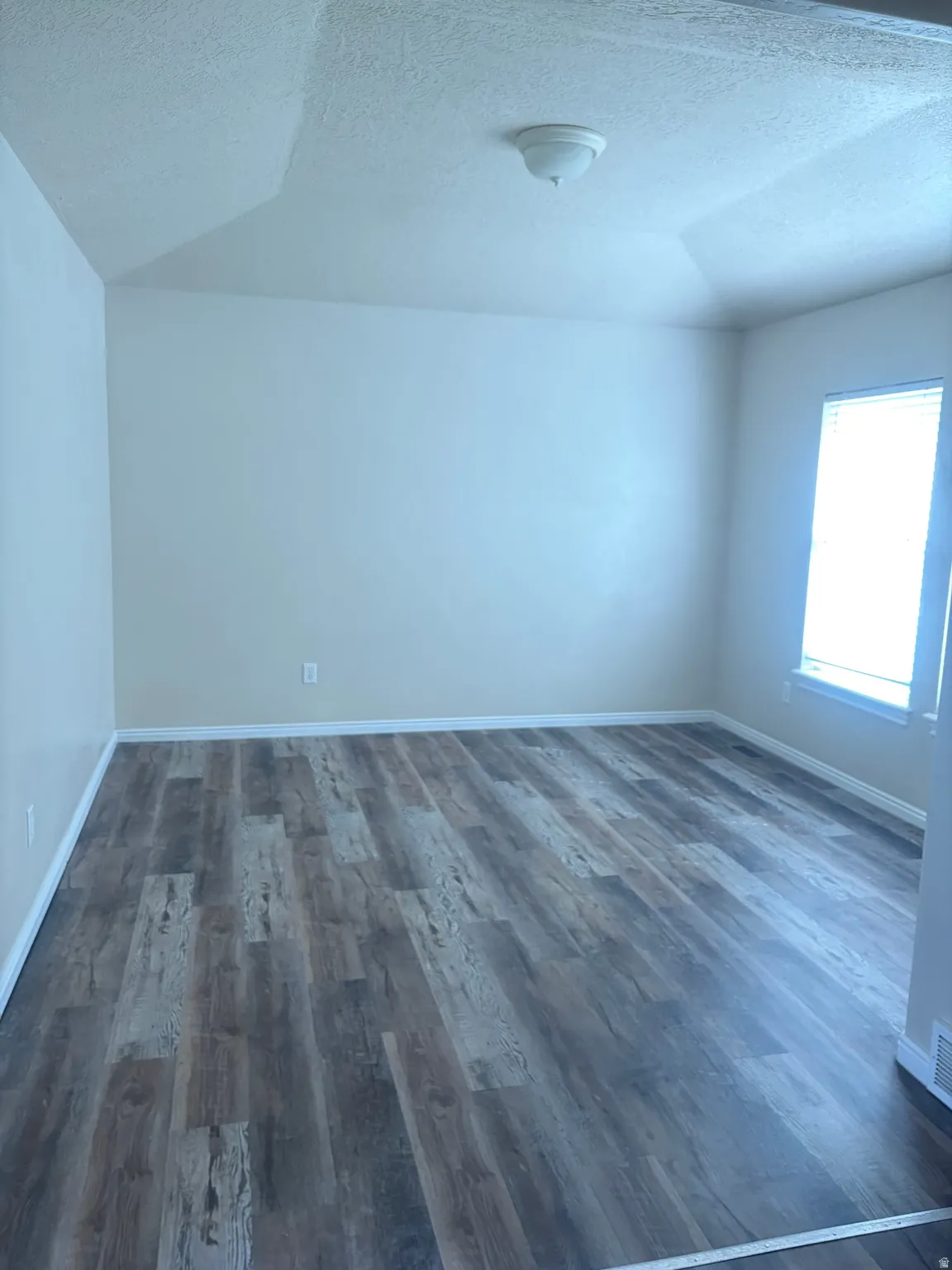 Unfurnished room with a textured ceiling and LVT floors