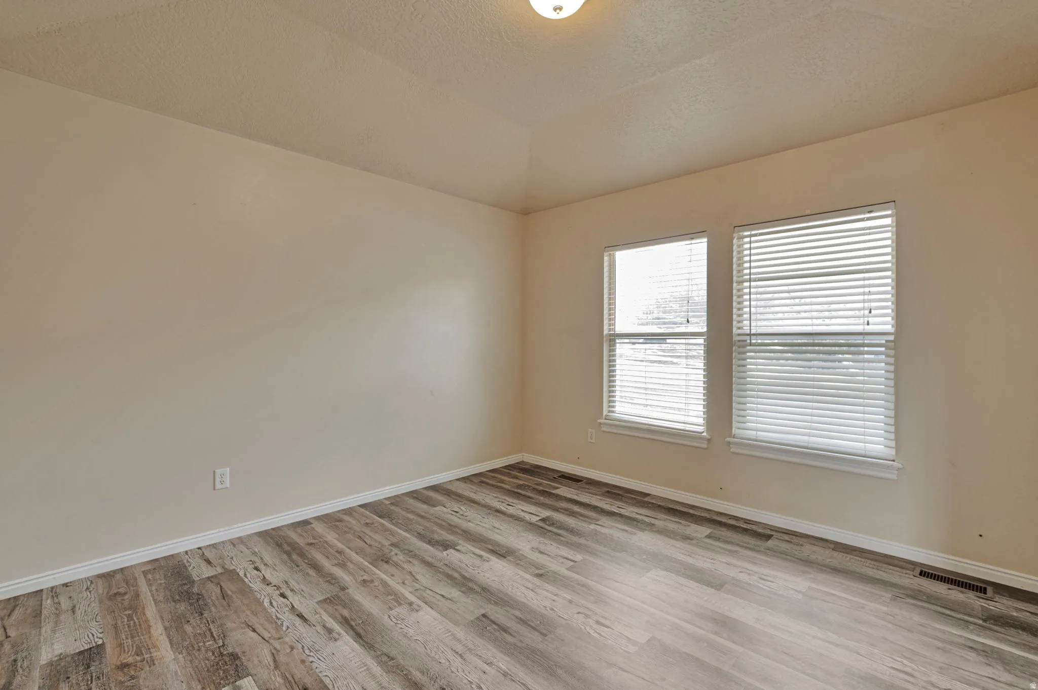 Empty room with light wood-style floors and baseboards