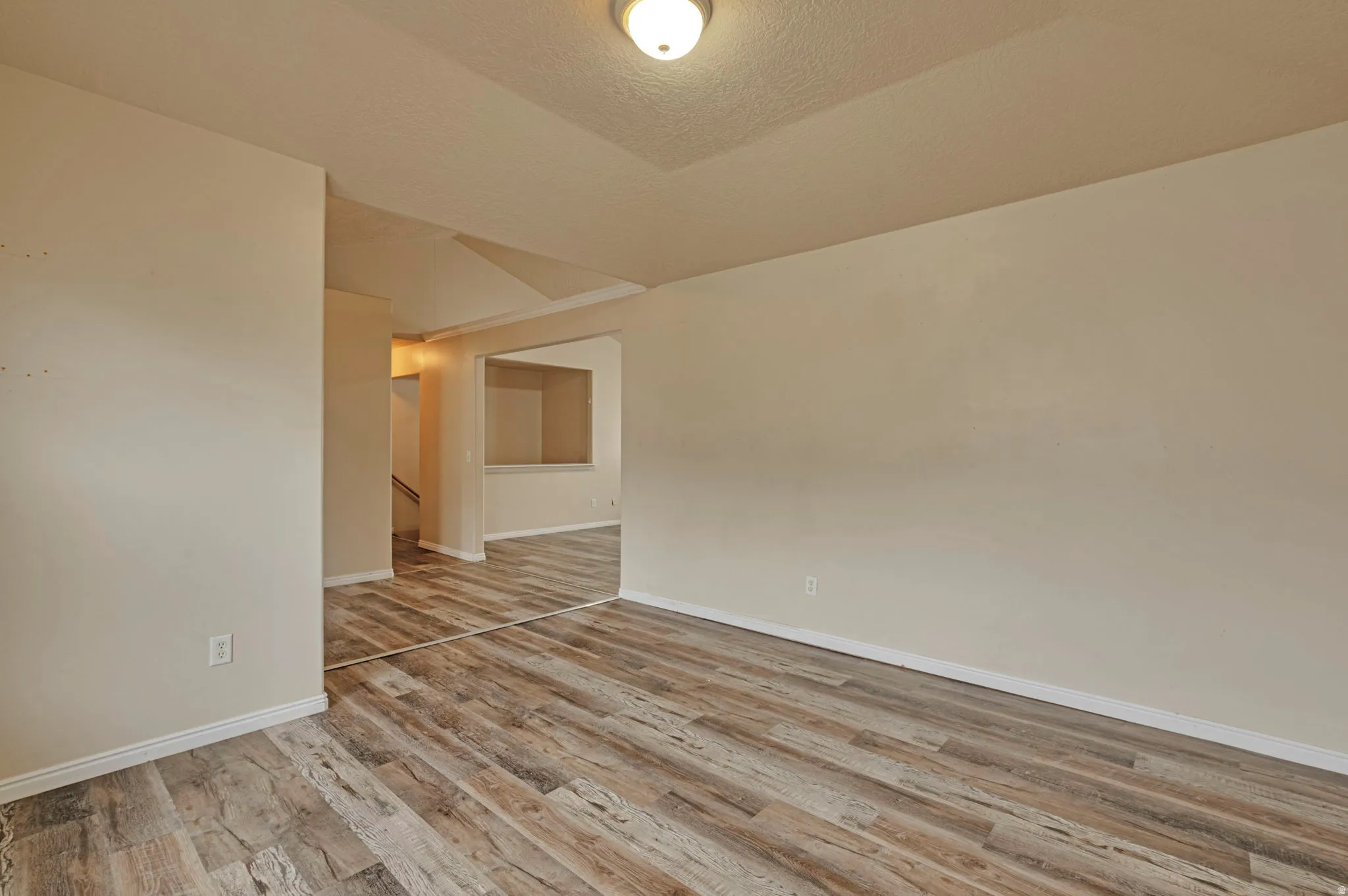 Spare room featuring light wood-style flooring and a textured ceiling