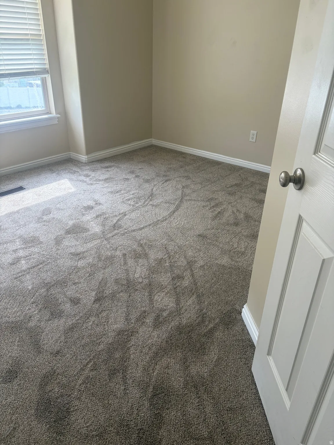 Spare room featuring baseboards and carpet