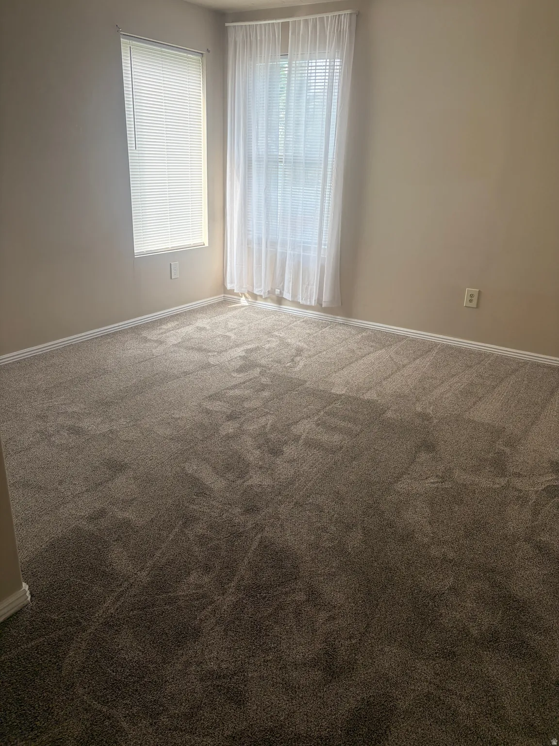 Carpeted empty room with baseboards
