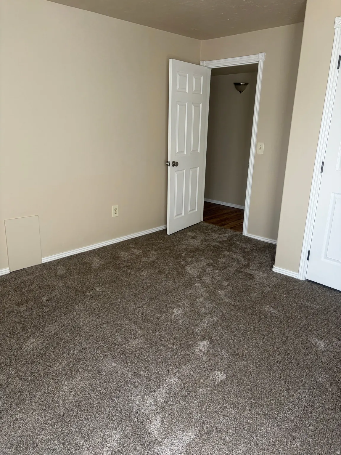 Unfurnished bedroom featuring dark carpet and baseboards