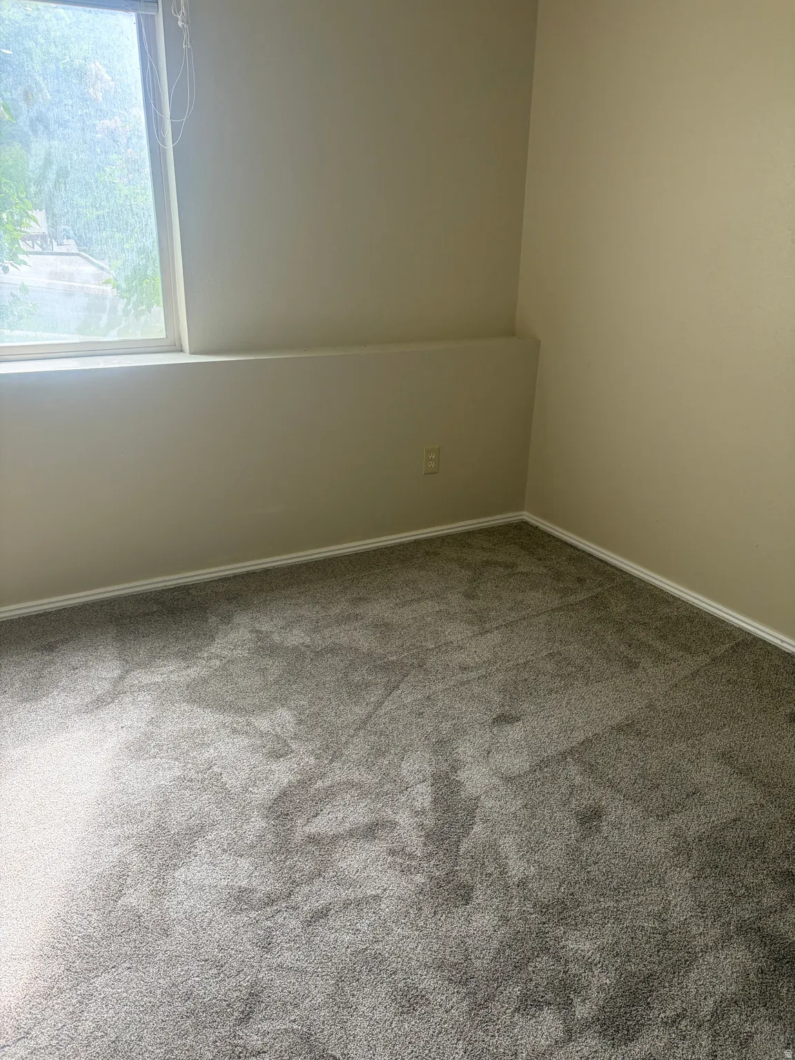 Carpeted empty room featuring baseboards