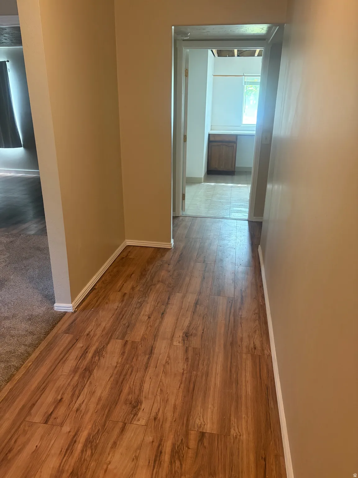 Corridor featuring baseboards and wood finished floors