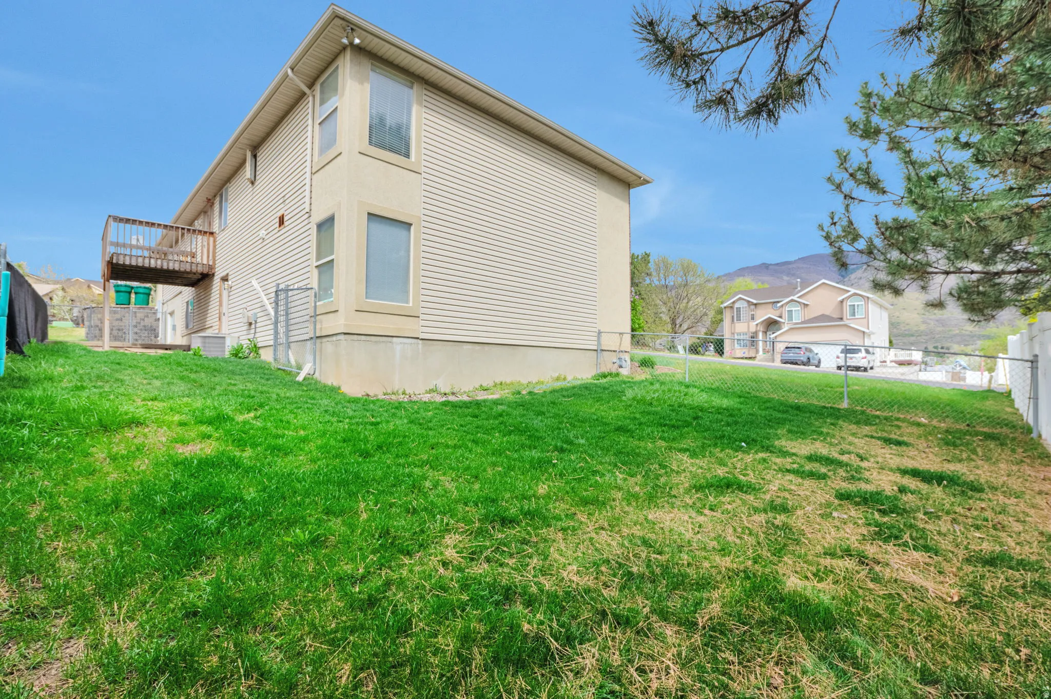 View of home's exterior featuring a fenced backyard and a deck with mountain view
